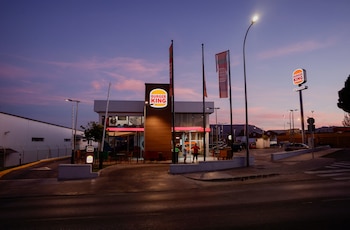 Clientes frente a un restaurante Burger King durante la puesta de sol, en Ronda, España, 25 de septiembre de 2024. (REUTERS/Jon Nazca)