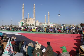 Manifestantes, partidarios de los hutíes, alrededor de una gran bandera palestina durante una concentración para conmemorar el primer aniversario de la guerra en la Franja de Gaza, en Saná, Yemen. (REUTERS/Khaled Abdullah)