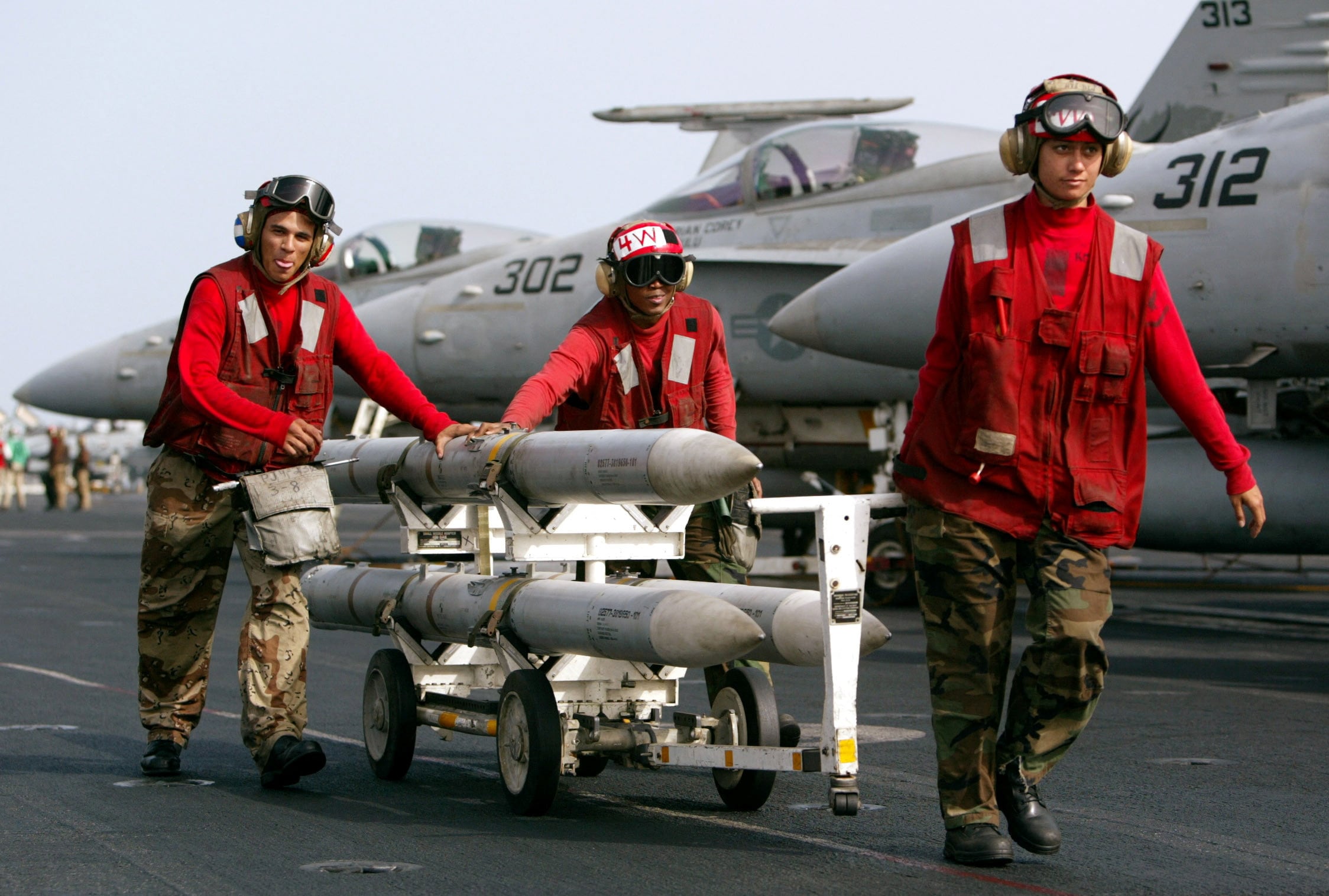 FILE PHOTO: AIM-120 AMRAAM air-to-air intercept missiles are wheeled past fighter jets on the deck of the USS Kitty Hawk in the northern Persian Gulf March 10, 2003. . REUTERS/Paul Hanna/File Photo