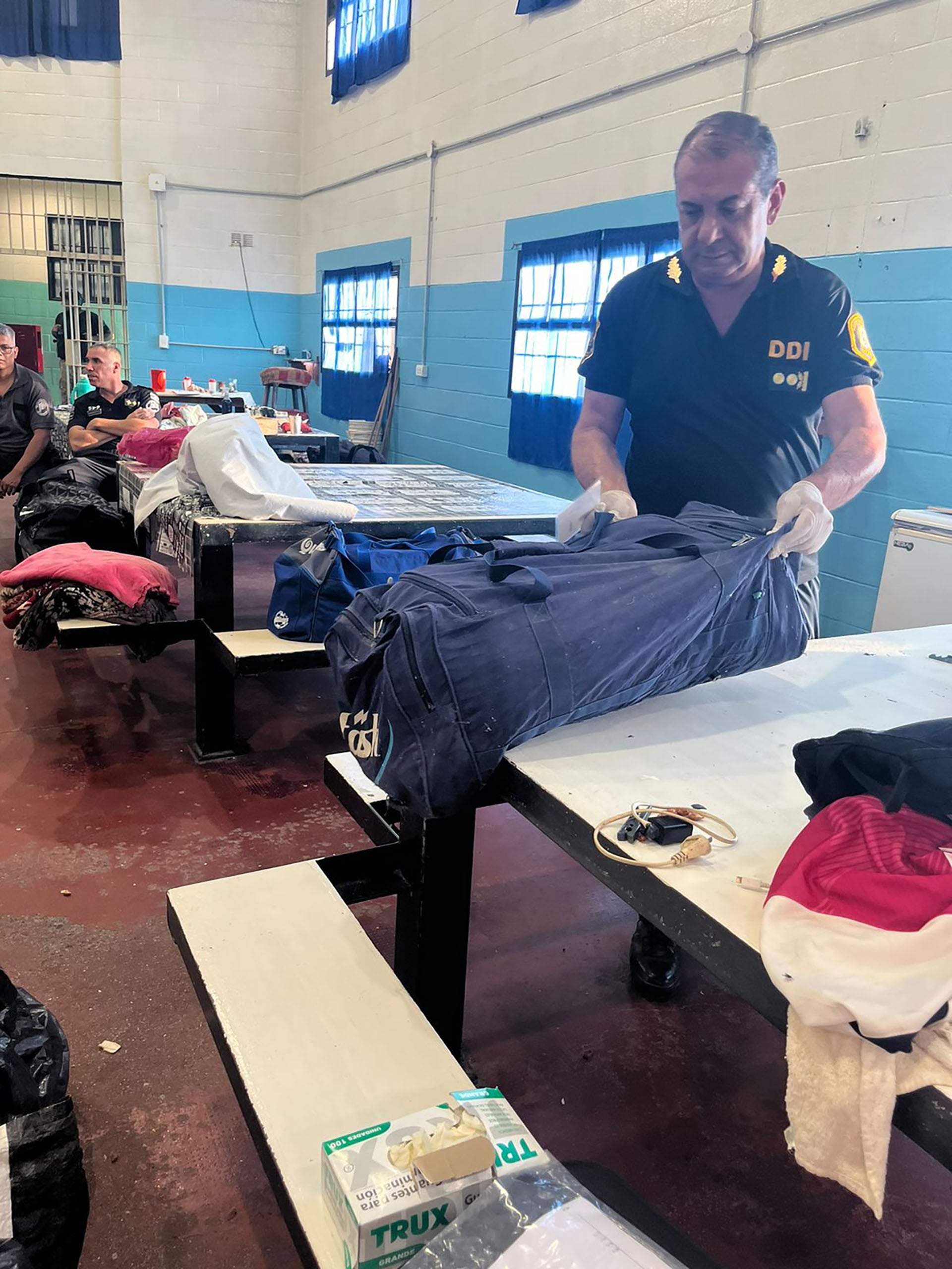 Agentes de la DDI realizan un operativo en Morón tras la condena de un hombre por abuso sexual sin contacto físico, revisando pertenencias en una habitación.