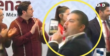 Un hombre enmarcado en un círculo amarillo sostiene un teléfono celular frente a personas que aplauden ante el logotipo de Morena