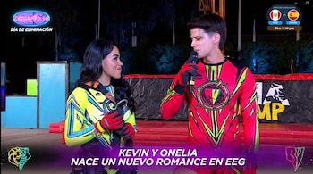 Kevin Díaz, con atuendo deportivo rojo y verde, sostiene un micrófono y mira a Onelia Molina, quien viste ropa deportiva amarilla y azul, en un set de televisión