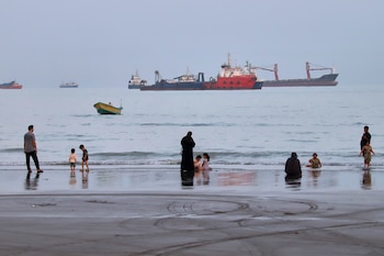 Gente pasa tiempo en la playa mientras se ven mercantes fondeados detrás en el estrecho de Ormuz, cerca de Bandar Abbas, Irán, el miércoles 5 de agosto de 2026
(Amirhosein Khorgooi/ISNA via AP)