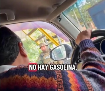 Imagen desde el interior de un coche: persona al volante interactúa con policía de camuflaje. Reflejo en espejo lateral. Texto: "NO HAY GASOLINA"