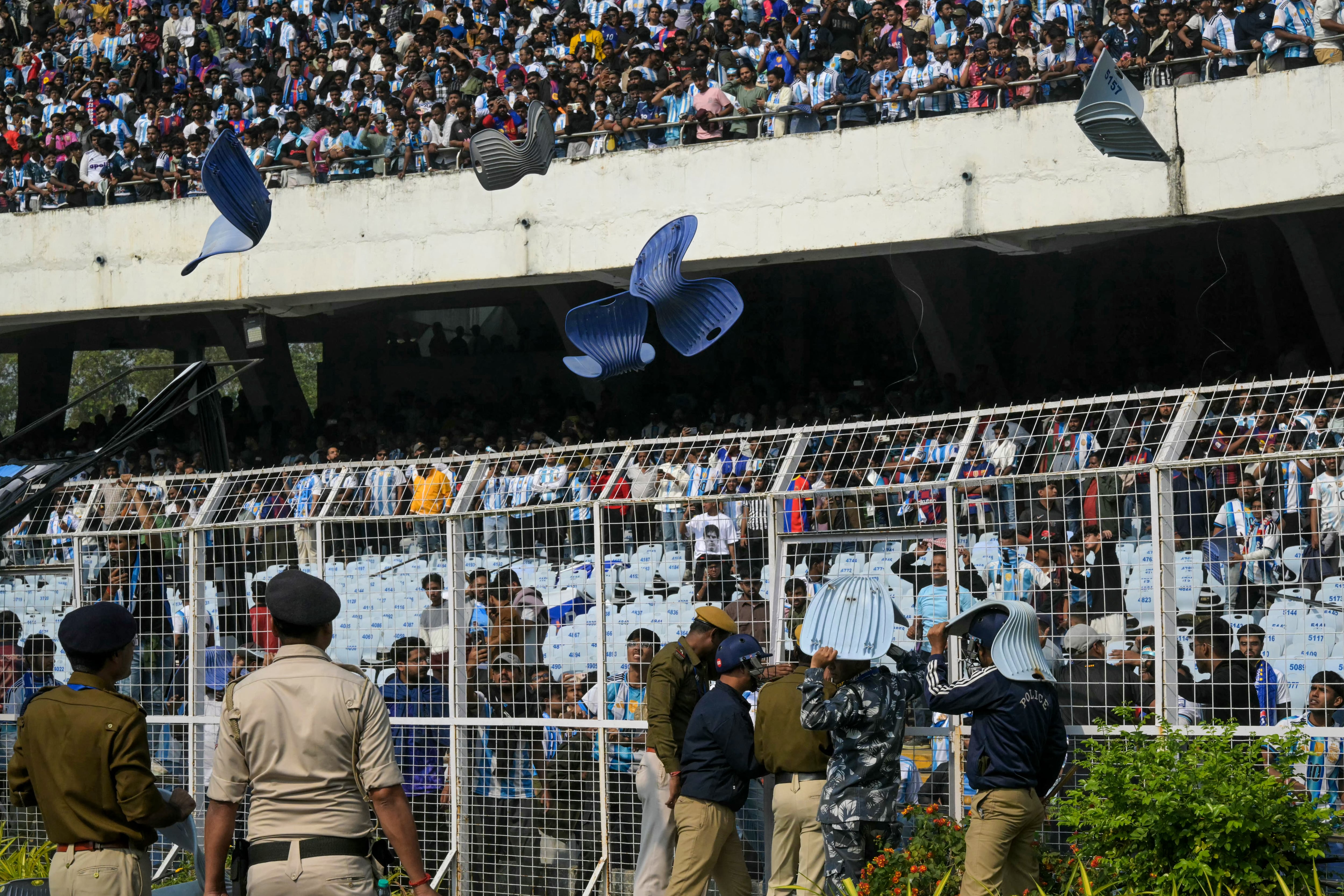 Los aficionados lanzan sillas cuando el delantero argentino del Inter Miami, Lionel Messi, abandona el estadio Salt Lake de Calcuta (Photo by Dibyangshu SARKAR / AFP)