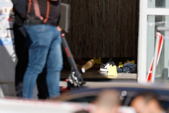 MATERIAL SENSIBLE. Miembros de las fuerzas israelíes trabajan mientras un cuerpo yace en la escena del ataque terrorista en una zona comercial en Beit Kama, sur de Israel (REUTERS/Carlos Garcia Rawlins)