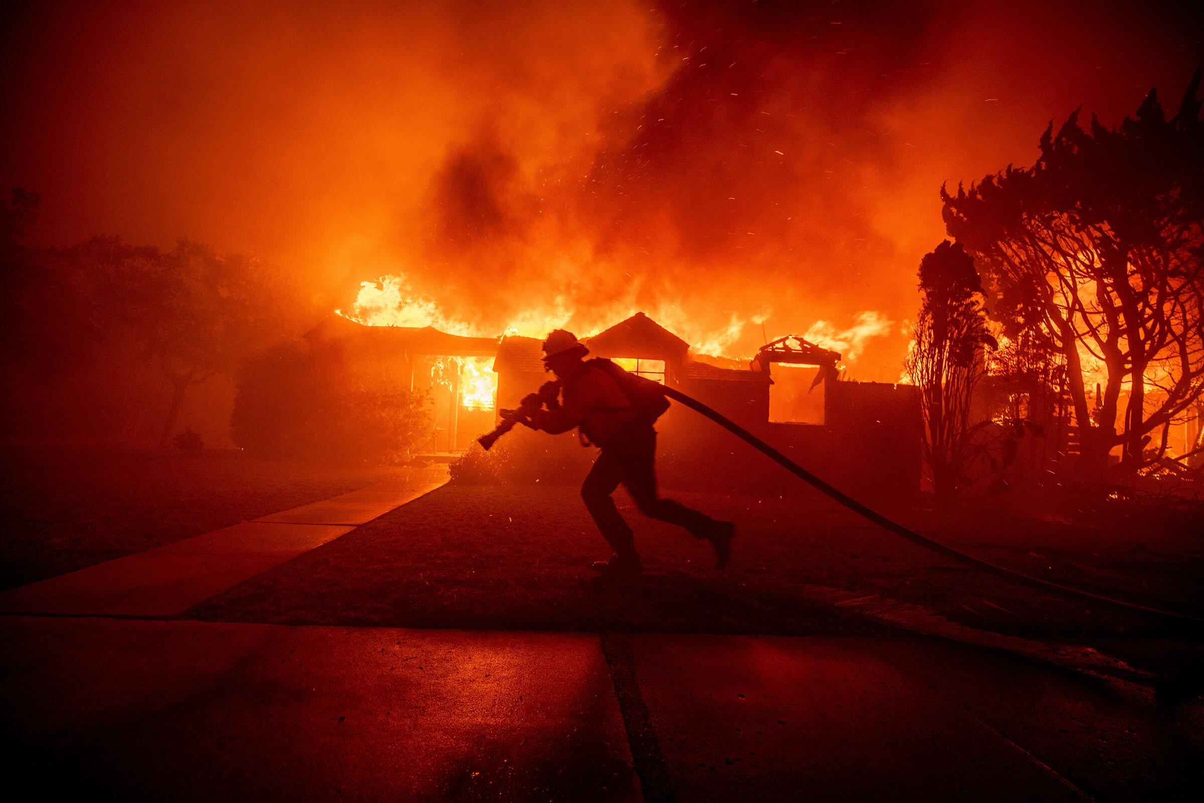 Un bombero combatiendo el incendio Palisades en el barrio Pacific Palisades de Los Ángeles, el 7 de enero (Ethan Swope—AP)