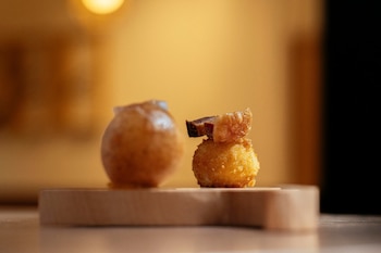 Croqueta de huevo frito y torreznos y buñuelo relleno de mantequilla con velo de papada ibérica, de Fendo (Web del restaurante)