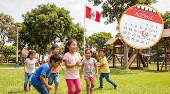 Seis niños ríen en un parque de pasto verde con árboles y juegos de madera. Una bandera de Perú y un calendario con el 16 de agosto marcado.