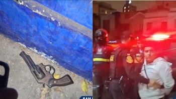 Un revólver sobre la acera junto a una pared azul y agentes policiales reteniendo a un hombre por la noche