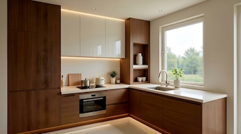 Vista frontal de una cocina moderna con gabinetes de madera oscura y blancos, encimeras claras, horno empotrado, placa de inducción y fregadero bajo una ventana.