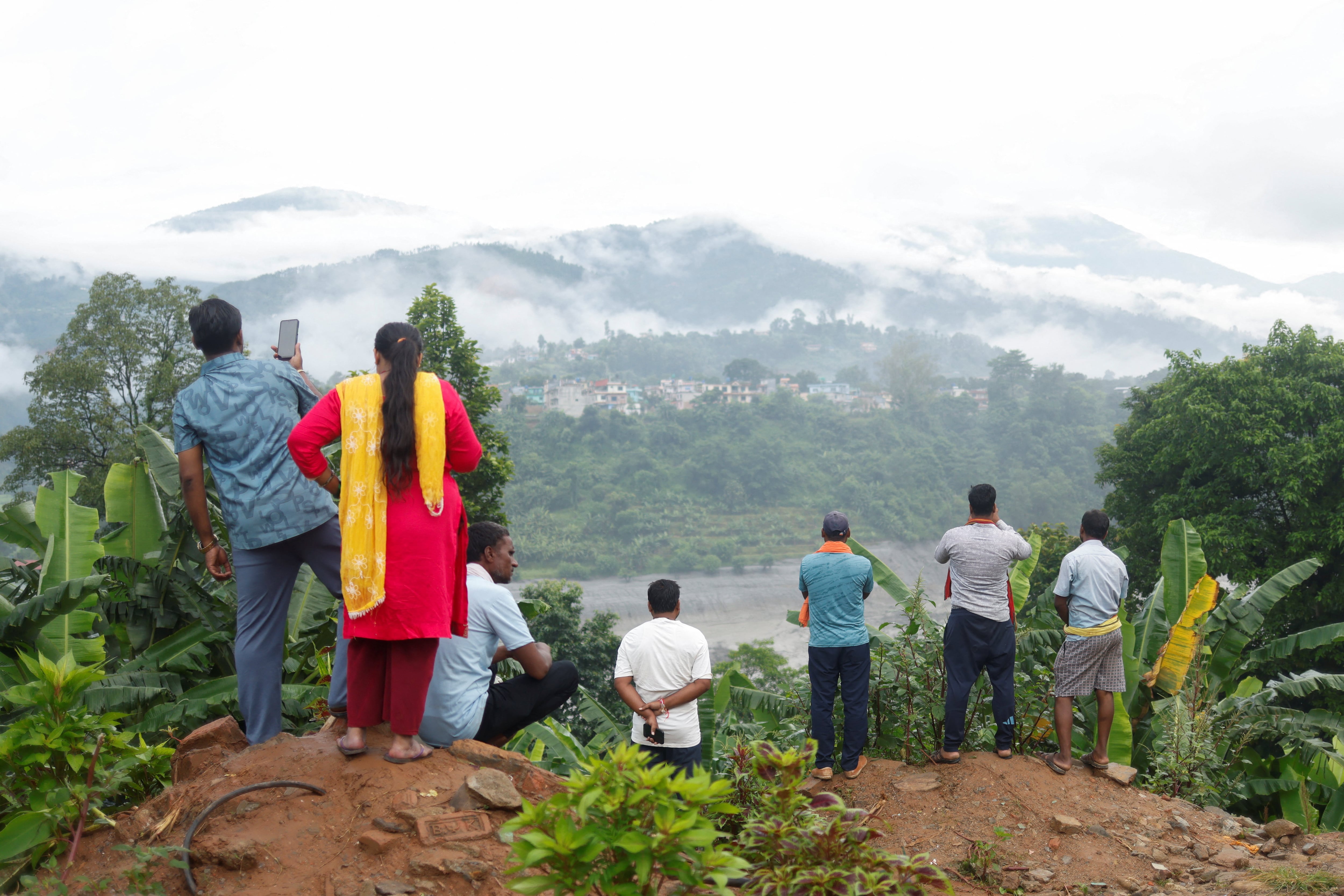 La gente observa la destrucción tras las inundaciones repentinas y un deslizamiento de tierra, en Trishuli, distrito de Nuwakot (REUTERS/Adnan Abidi)