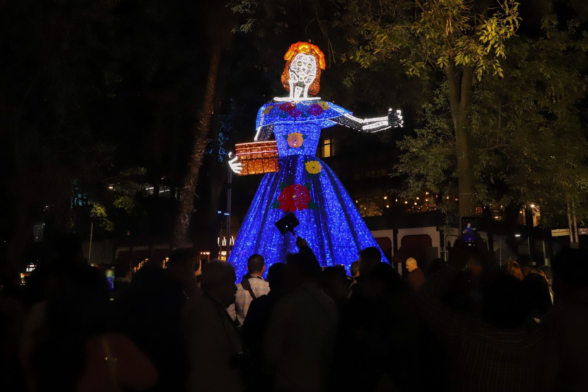 La instalación inmersiva “El Camino: Iluminación en Reforma” recorre Paseo de la Reforma desde el Ángel de la Independencia hasta la Puerta de los Leones. El montaje incluye túneles de luz, arreglos florales y esculturas iluminadas con representaciones de xoloitzcuintles, catrinas, papel picado y altares. FOTO: DANIEL AUGUSTO/ CUARTOSCURO.COM