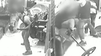 Imagen de cámara de seguridad en blanco y negro, dividida. Un hombre con una barra metálica dentro de una barbería. Un forcejeo entre varias personas en el mismo lugar