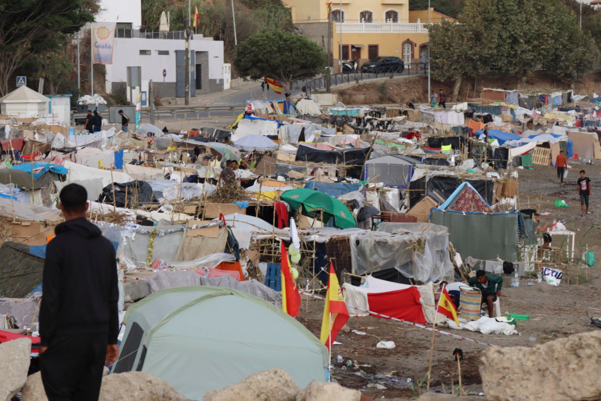 Vista de las tiendas de campaña y construcciones improvisadas por los migrantes asentados en la playa del Trampolín, esta mañana en Ceuta (EFE/ Reduan)
