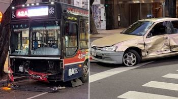 Un colectivo urbano con la parte delantera destruida junto a un vehículo con la puerta y el parabrisas dañados en una vía pública.