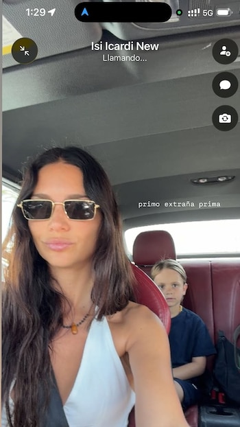 Una mujer con gafas de sol en el asiento delantero de un automóvil, un niño en el asiento trasero y una pantalla de teléfono con textos de llamada y mensaje