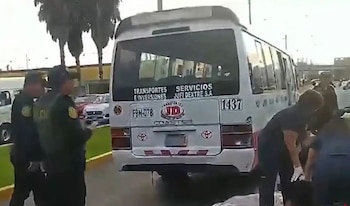 Un autobús blanco con placa F9N-078 permanece detenido en una vía pública junto a policías y personal de emergencia