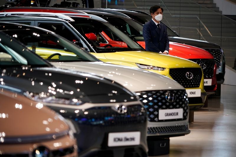 FOTO DE ARCHIVO: Un empleado con una máscarilla para evitar contraer la enfermedad del coronavirus (COVID-19) espera junto a un vehículo de Hyundai Motor en Hyundai Motor Studio en Goyang, Corea del Sur, 21 de abril de 2020 (REUTERS/Kim Hong-Ji)