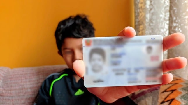 Un menor de edad sostiene su nuevo DNI electrónico, luego de que sus padres hicieran el trámite para cambiar su antiguo documento de identidad color amarillo. (Andina)