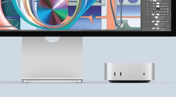 Un Apple Mac Studio o Mac mini plateado, con un monitor mostrando una interfaz de software de diseño gráfico con formas abstractas coloridas y paneles de capas