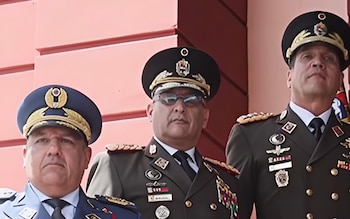 Primer plano de tres oficiales militares de pie: uno de la fuerza aérea con uniforme azul y dos del ejército con uniforme verde oscuro