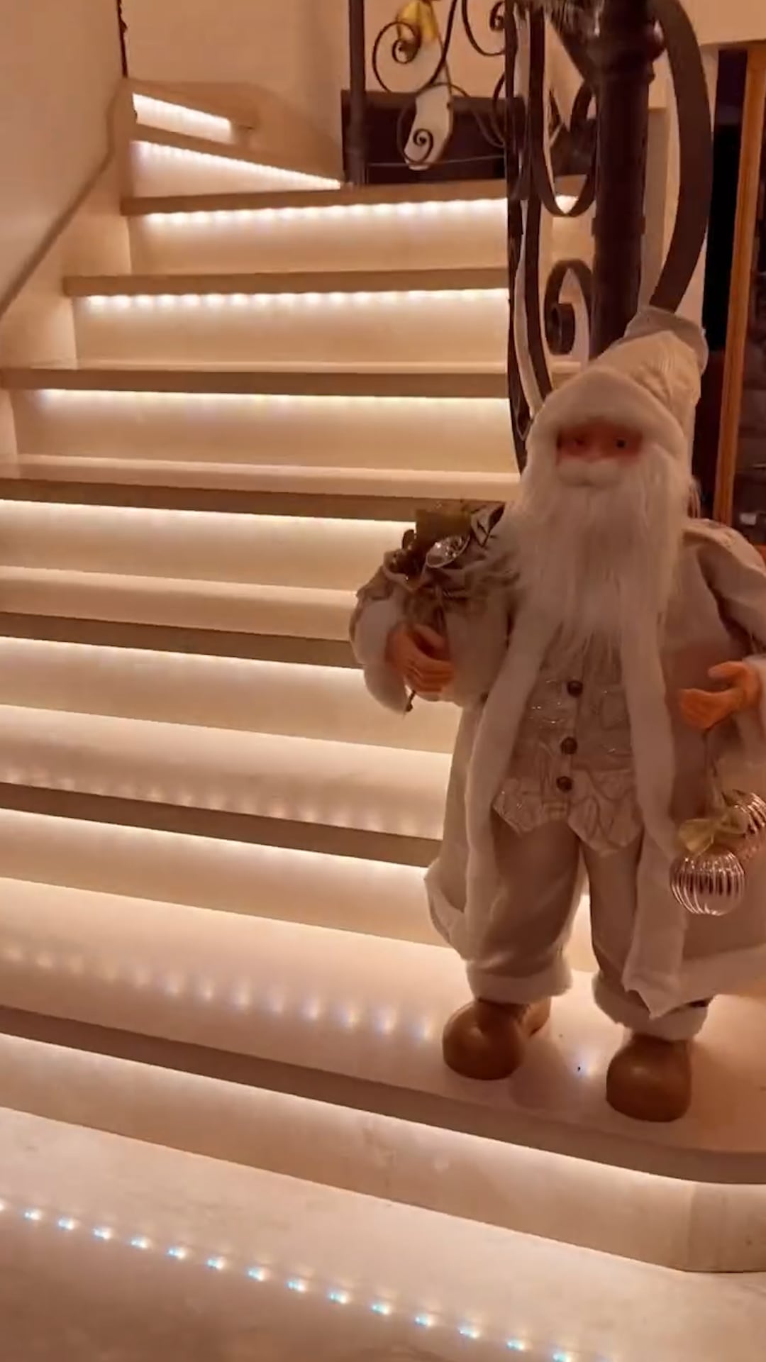 Medias navideñas y luces cálidas en la escalera, un sello del interior de la casa