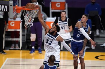 El centro de los Minnesota Timberwolves, Karl-Anthony Towns (32), clava el balón sobre el alero de Los Angeles Lakers, Kyle Kuzma (0) y el alero LeBron James (23) en la segunda mitad en el Staples Center (Crédito obligatorio: Kirby Lee-USA TODAY Sports)