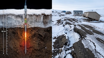 Sonda de medición insertada en el suelo bajo una capa de nieve junto a una carretera agrietada y casas inclinadas.
