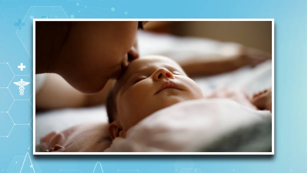 A parent kissing a baby.