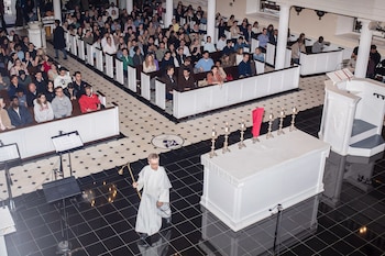 Los feligreses sentados en los bancos para la popular misa católica del domingo por la noche en la iglesia de San José. (Bryan Anselm/Para The Washington Post)