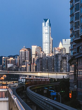 El monorraíl elevado atraviesa edificios en Chongqing, convirtiéndose en un atractivo turístico y ejemplo de diseño innovador en urbanismo (Wikipedia)
