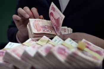 Un empleado cuenta billetes de renminbi chino en un banco de Baokang, en la provincia central china de Hubei (Reuters)
