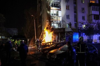 Varios bomberos trabajan en el sitio de un edificio de apartamentos golpeado por un ataque de drones rusos en Kiev, Ucrania (REUTERS/Gleb Garanich)