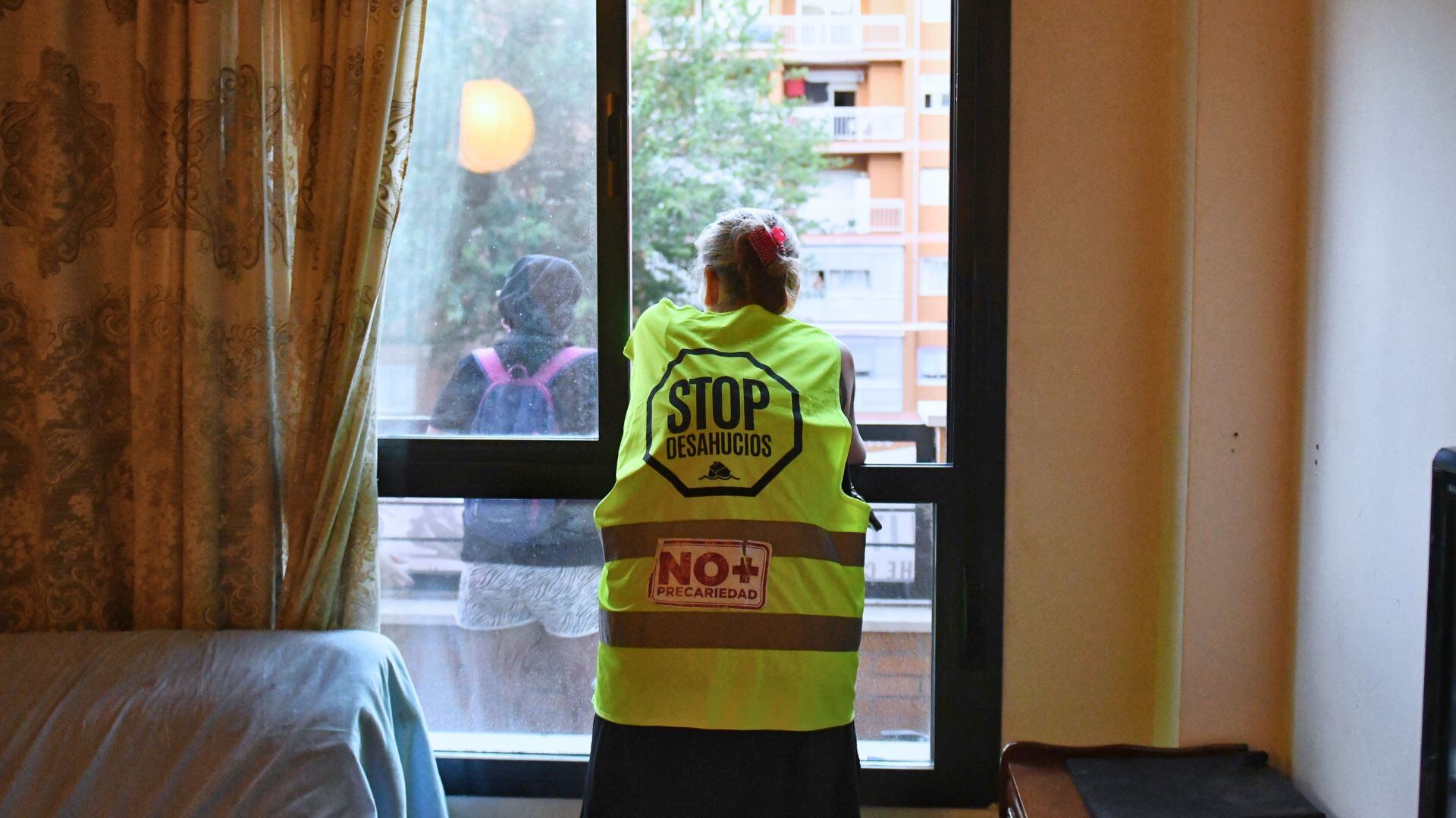 Una mujer se asoma al balcón de su casa antes de ser desahuciada (Fernando Sánchez / Europa Press)