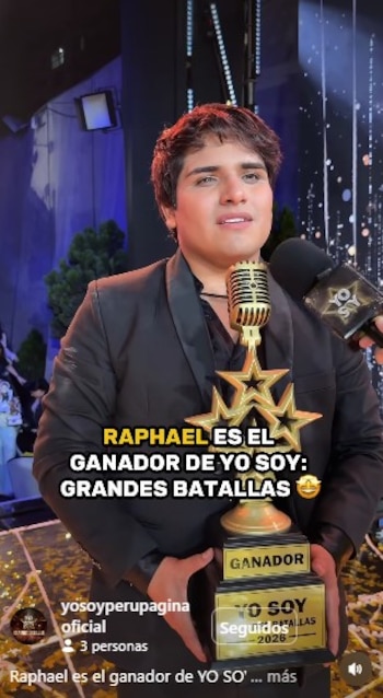 Un hombre joven, el imitador de Raphael, con cabello oscuro y chaqueta negra, sostiene un trofeo dorado con estrellas mientras habla por un micrófono retro