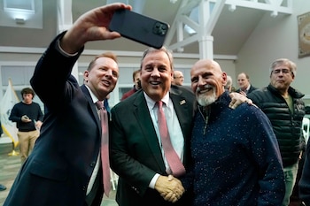 El exgobernador de Nueva Jersey, Chris Christie, al centro, posa para una foto después de una plática en el New England College, el 20 de abril de 2023, en Henniker, Nuevo Hampshire. (AP Foto/Charles Krupa)