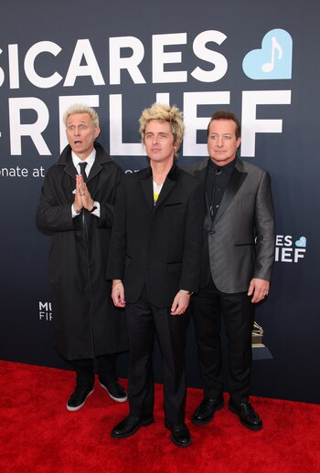Mike Dirnt, Billie Joe Armstrong y Tré Cool, integrantes de Green Day, asistieron al evento con estilos que combinaron elegancia y toques de personalidad distintiva. Billie Joe Armstrong optó por un traje negro de corte clásico, mientras que Mike Dirnt lució un abrigo largo negro sobre un conjunto formal. Tré Cool añadió un toque sofisticado con un traje gris oscuro y camisa negra