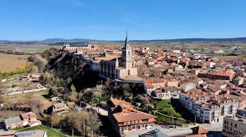 Las casas del pueblo y se aprecia el altozano en el que se sitúa la colegiata. Campos castellanos al fondo.