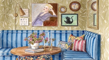 Sofá azul a rayas, mesa de madera con jarrón de flores, libros, velas, cojines, pared con papel pintado, lámpara, retratos, cisne negro y espejos.