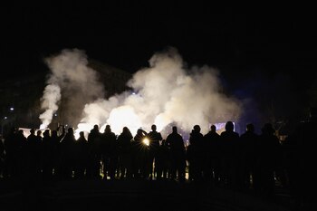 Los manifestantes encienden bengalas durante
