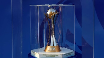 Primer plano del trofeo de la Copa Mundial de Clubes de la FIFA, plateado y dorado con un globo terráqueo en la parte superior, dentro de una vitrina de cristal