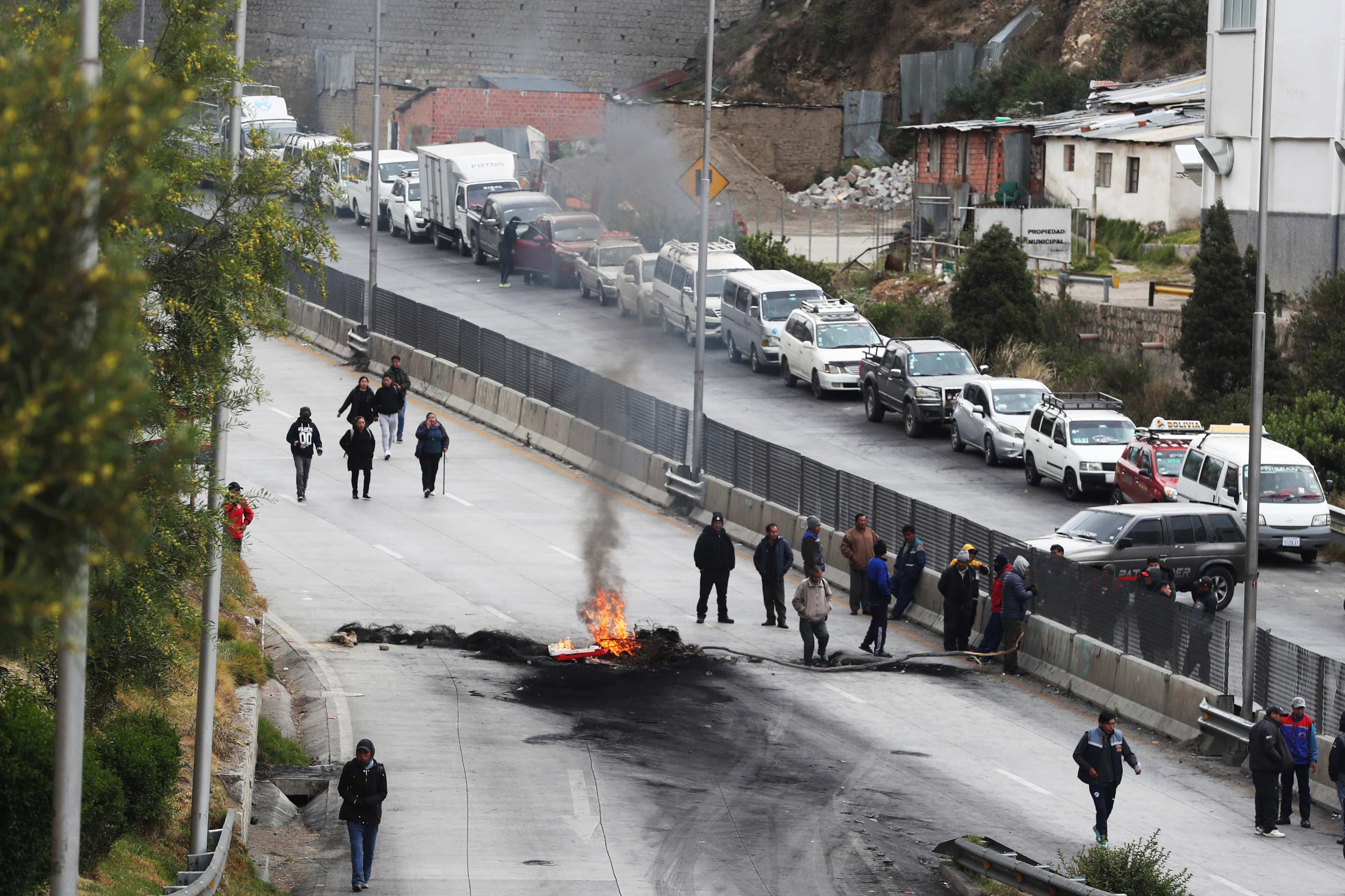 Personas realizan un bloqueo en la vía que conecta las ciudades de El Alto y La Paz (Bolivia). EFE/Luis Gandarillas