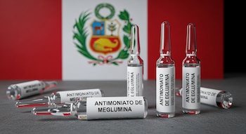 Varias ampollas de Antimonato de Meglumina sobre una superficie oscura. En el fondo, una bandera de Perú con su escudo nacional.