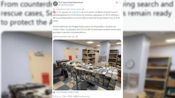 Grandes paquetes rectangulares, que se presume contienen cocaína, apilados sobre una mesa metálica en un almacén. Al fondo, se ven estanterías y un reloj de pared