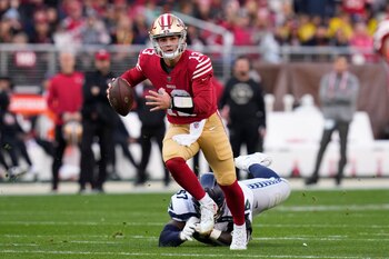 El quarterback de los 49ers de Filadelfia Brock Purdy pelea para superar al defensive tackle de los Seahawks de Seattle Poona Ford en el encuentro de comodín el sábado 14 de enero del 2023. (AP Foto/Godofredo A. Vásquez)
