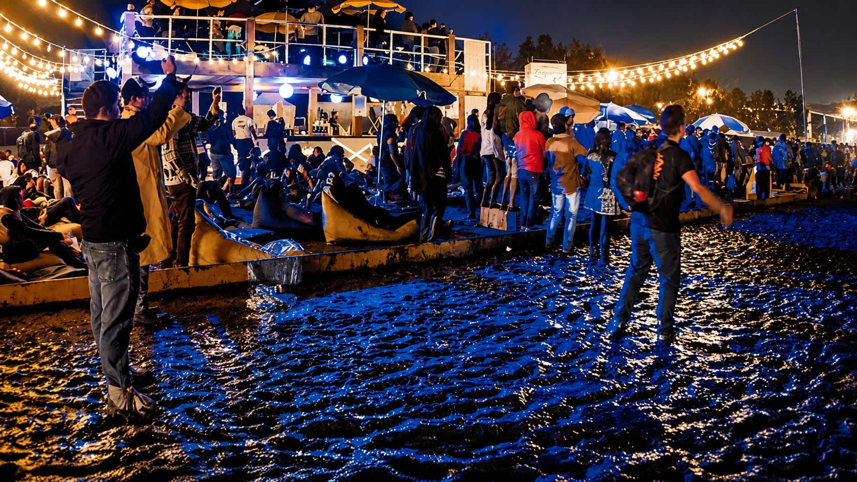 La multitud de asistentes al festival Tecate Emblema transita por el terreno encharcado y fangoso, iluminado por luces de guirnalda, tras dos días de lluvia. (Instagram)