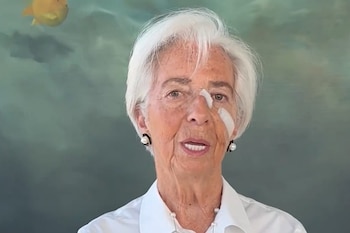 Primer plano de Christine Lagarde con el cabello blanco, camisa blanca y tiras adhesivas sanitarias colocadas sobre la nariz y el pómulo izquierdo
