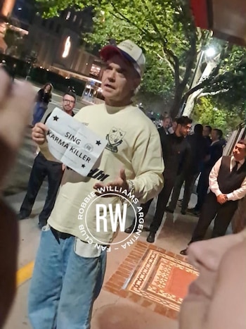 Robbie Williams sorprendió a sus fans con un show acústico en la puerta de su hotel