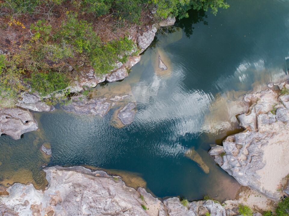 Vista aérea del río Sapo, conocido por la pureza de sus aguas y rodeado de formaciones rocosas y vegetación en el norte de Morazán, El Salvador (Foto cortesía Salvando río Sapo).